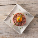 La tartare di carne è un piatto ideale per l'estate. Scopriamo come preparare una tartare di carne e come abbinare il vino